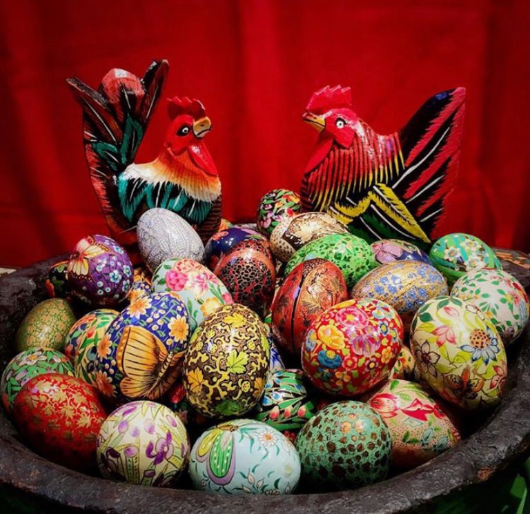 Bowl of hand-painted eggs decorated with birds and flowers