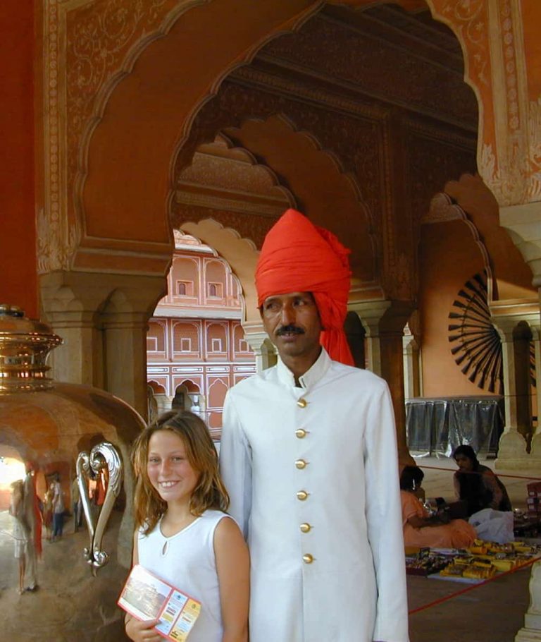 Standing with a palace guard in his white coat and scarlet turban