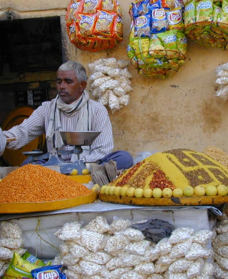 Sweet seller weighing saffron treats on brass scales