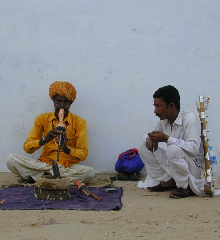 Snake charmer in marigold yellow playing the pungi