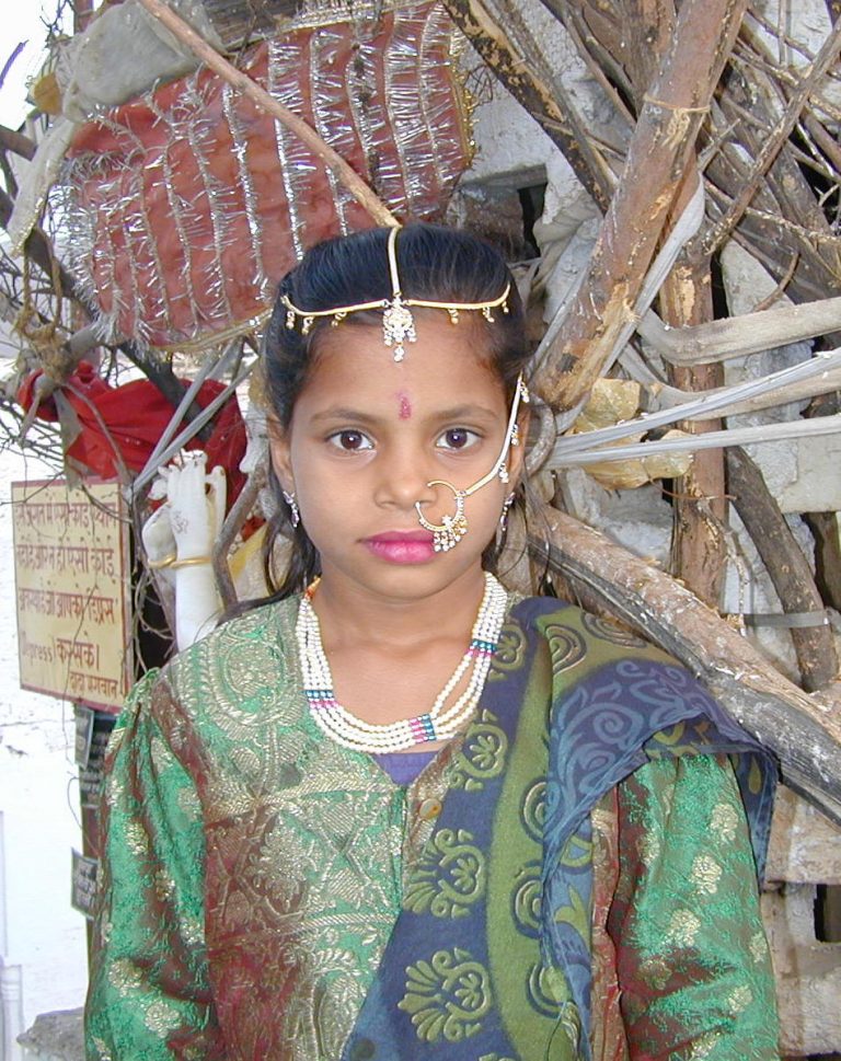 Young girl in a beaded headpiece, nose ring and layered necklaces