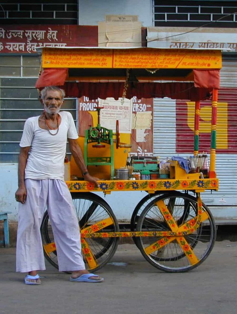 Chai seller standing proudly at his hand-painted yellow street cart