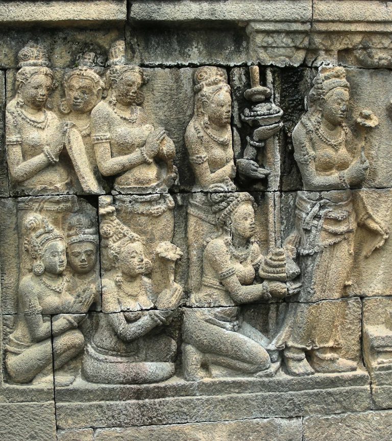 Kneeling devotees carved in stone on an ancient temple wall